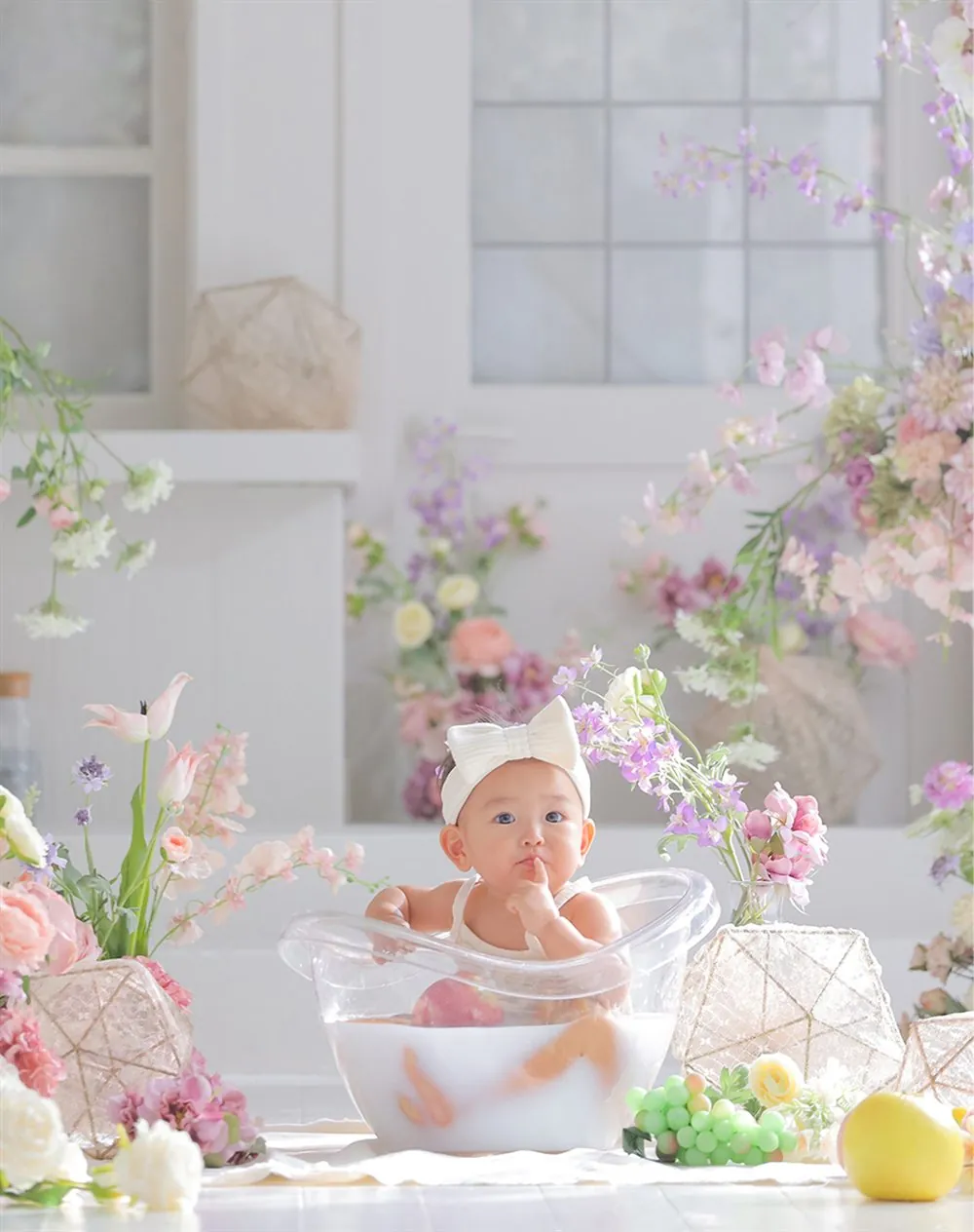 花に囲まれてミルクバスに入る1歳の女の子