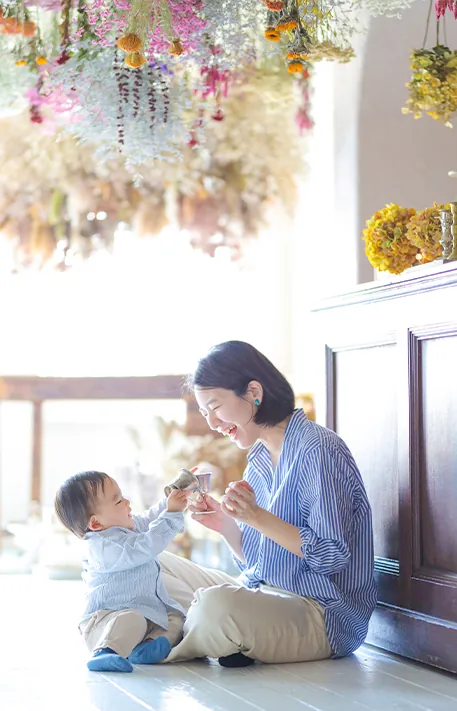 床に座って子どもと向き合うお母さん