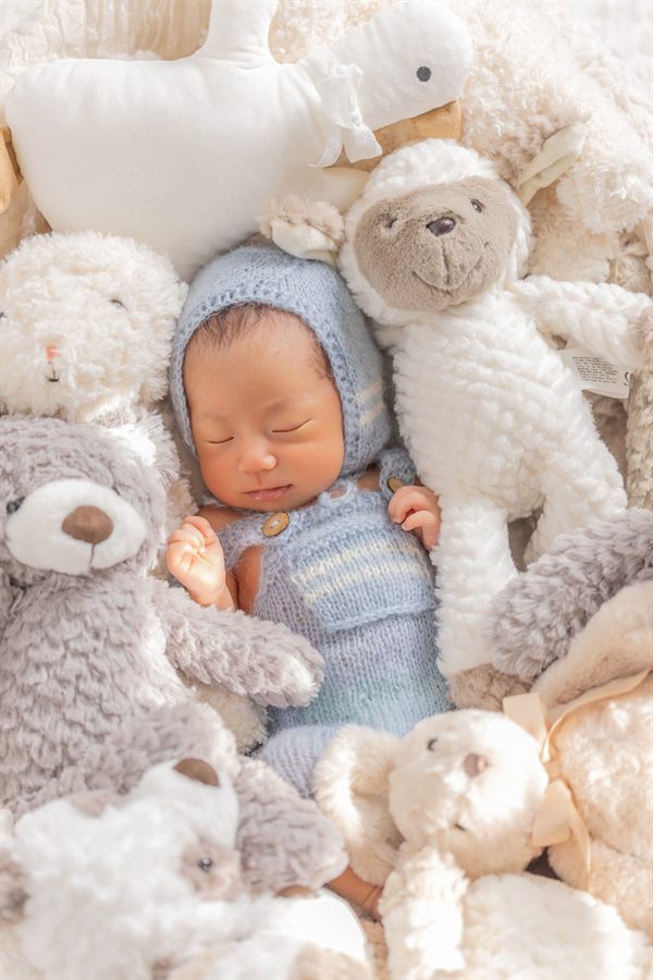 水色のニット衣装を着た新生児